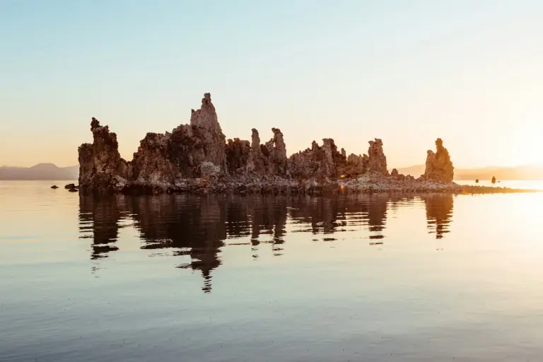 tufa towers reflected in the calm water of Mono Lake at sunrise