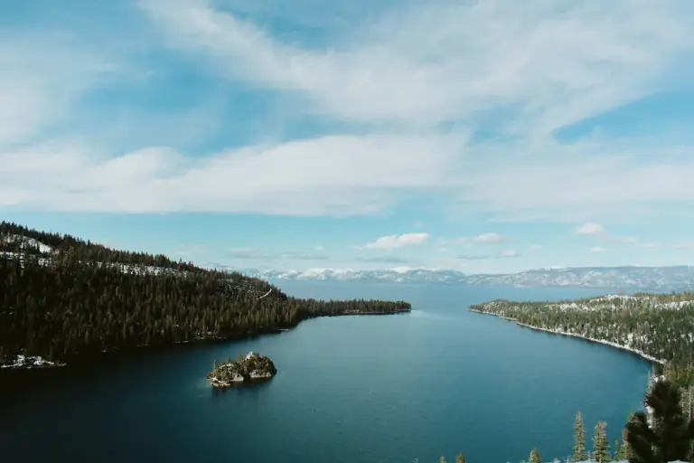 Lake Tahoe surrounded by snow-covered mountains and evergreen forest